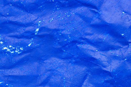 Crumpled sheet of blue paper close-up.