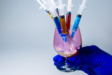 Set of medical syringes in a glass with colored injections for cosmetology hand beautician. The cocktail of the beautician for skin rejuvenation.