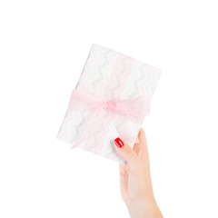Woman hands give wrapped Christmas or other holiday handmade present in colored paper with pink ribbon. Isolated on white background, top view. thanksgiving Gift box concept