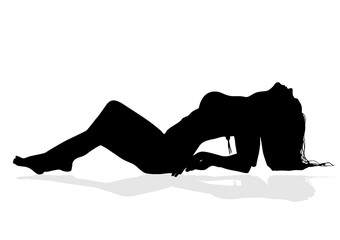 Silhouette of a beautiful slender girl with long hair who lies on t he beach and arches her body, protruding large breasts
