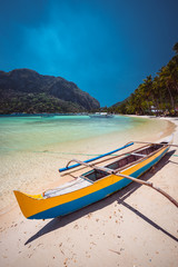 Fototapeta na wymiar Traditional wooden banca boat on beautiful Corong Corong beach near El Nido village. Summer exotic vacation and Island hopping concept. Philippines