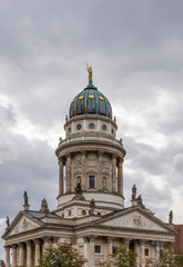 Fototapeta na wymiar Vertical image of the Franzosischer Dom in the Gendarmenmarkt square, Berlin, Germany, on a typical winter day with cloudy skies