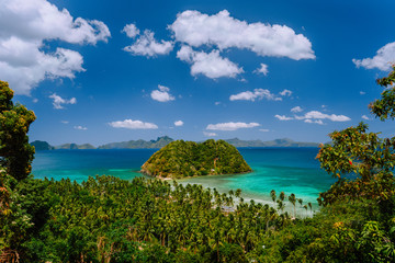 Tropical scenery of bacuit archipelago with palm trees, island and blue lagoon. El Nido, Palawan, Philippines