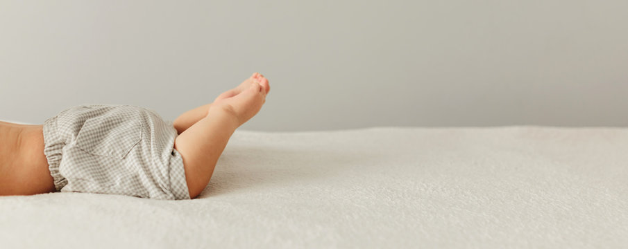 Portrait Of A Cute 3 Months Baby Lying Down On A Blanket, Beautiful Babys Legs On Bad