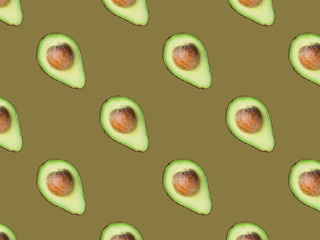 Seamless diagonal pattern of halved ripe avocados with pit on beige greenish background. Creative food backdrop for culinary cooking oil healthy lifestyle natural cosmetics