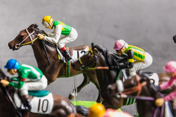 Galloping jockeys and race horses toy competing for position.Concept to compete for victory.