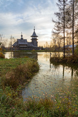 Fototapeta na wymiar Wooden orthodox church of the Annunciation and its reflection in the lake on an autumn day. Moscow region, Sergiev Posad district. The Blagoveshheniye village