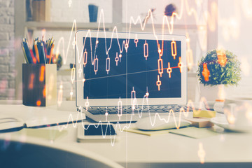 Stock market graph on background with desk and personal computer. Multi exposure. Concept of financial analysis.