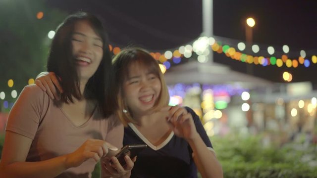 Tourist Asian sister girls direction on location in Bangkok, Thailand. Young student women using mobile phone looking on map find landmark while spending holiday trip. Lifestyle family travel in city.