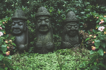 sculptures of  Dol Hareubangs on rainy day with green plants