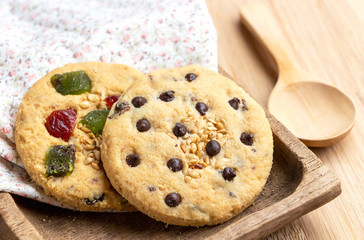 Mixed fruits cookie and Chocolate chip with wooden tray on the wood table. Delicious homemade baked cookie.