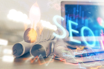 Multi exposure of table with computer and seo drawing hologram. Search optimization concept.