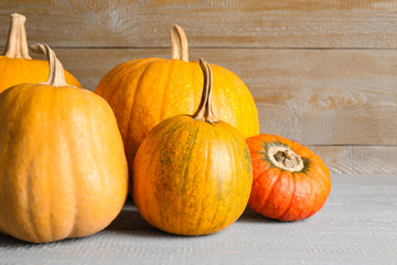 Many different ripe pumpkins on wooden table