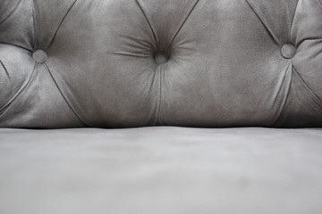 Detail of classical furniture. Velour sofa close-up with part of the seat. Gray padded fabric...
