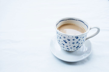 Coffee in a white mug with a blue pattern placed on the table