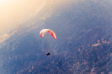 Close up of a Flying colorful parachute paragliding on beautiful mountain background. Solang...