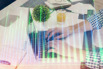 Obraz premium Multi exposure of graph with man typing on computer in office on background. Concept of hard work. Closeup.