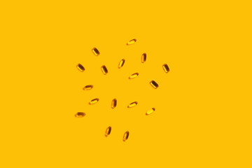 Pills omega 3 on a yellow background.