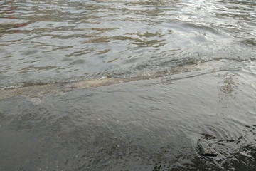 view of dirty water flood on the road and foot patch with heavy raining in city, pollution issues in city.