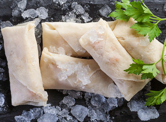 rollito de primavera chino, sin cocinar con una rama de perejil verde