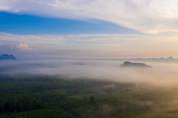 Aerial view of mountains with cloud cover mountain at sunrise and blue sky in Surat Thani Province, Thailand.