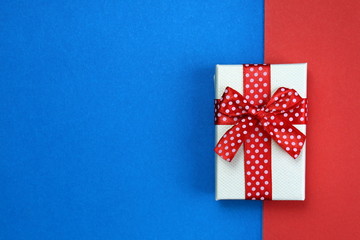 a gift box lies immediately on two backgrounds red and blue