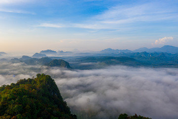 Aerial view of mountains with cloud cover mountain at sunrise and blue sky in Surat Thani Province, Thailand.