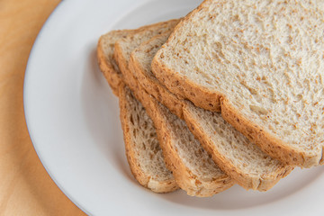 Sliced bread on white dish, wood background