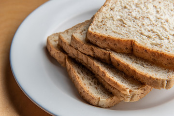 Sliced bread on white dish, wood background