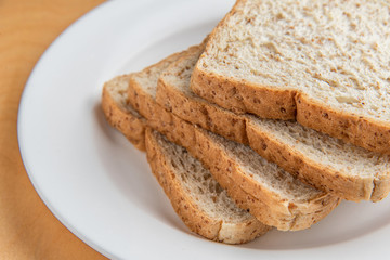 Sliced bread on white dish, wood background
