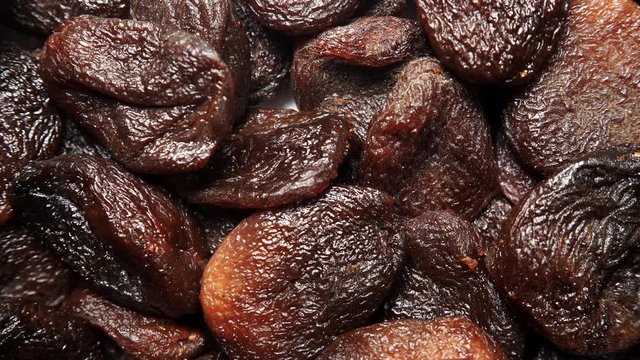 Brown dark color dried apricots as natural food background. Top view. Healthy food. Organic fruit not treated with sulfur dioxide