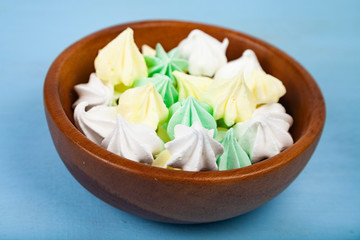 Meringue in a bowl on a wooden background.