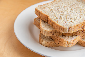 Sliced bread on white dish, wood background