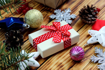gift box surrounded by christmas items on wooden background