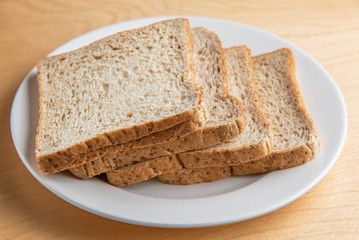 Sliced bread on white dish, wood background