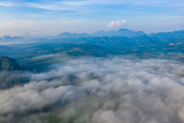 Aerial view of mountains with cloud cover mountain at sunrise and blue sky in Surat Thani Province, Thailand.