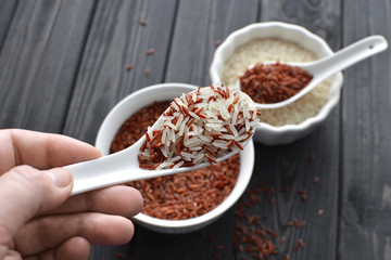 hand holdind a spoon with red and steamed rice mix