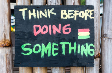 Fototapeta premium Handmade painted sign reads think before doing something