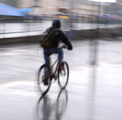 Naklejka premium Cyclist on the city roadway in motion blur. Intentional motion blur