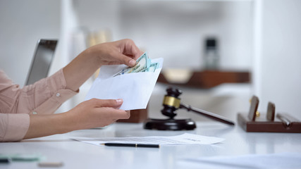 Divorced woman holding envelope with dollars, savings for single mom, allowance