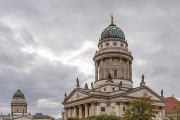 Fototapeta na wymiar The twin churches of the Gendarmenmarkt square in Berlin, Germany, under a typically winter and cloudy sky