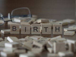 The concept of Birth represented by wooden letter tiles