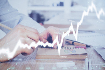 Multi exposure closeup hands with stock market forex graph.