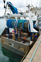 fishermen repair fishing nets on their fishing boat in the harbor