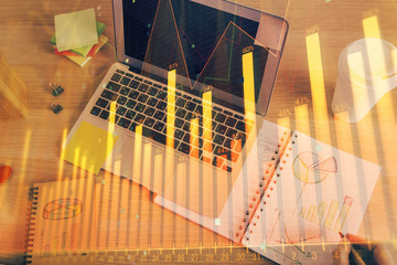 Double exposure of man's hands writing notes of stock market with forex chart.