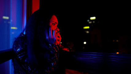 Frightened woman calling police, informing about disorder at night private party