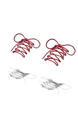 Photo of a pair of red shoelaces tied with a bow hanging in the air and casting a shadow. The picture was taken in the studio on a white background
