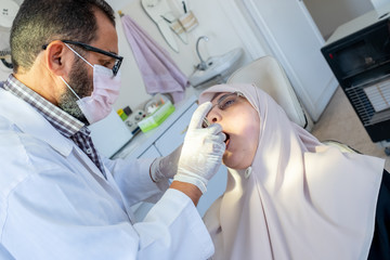 Dentist treating his patient teeth from ache