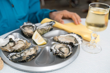 close up of delicious fresh oysters on the half shell with a glass of French white wine