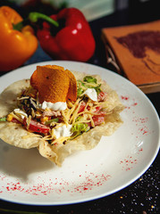 fresh vegetable salad in flatbread crust garnished with chips